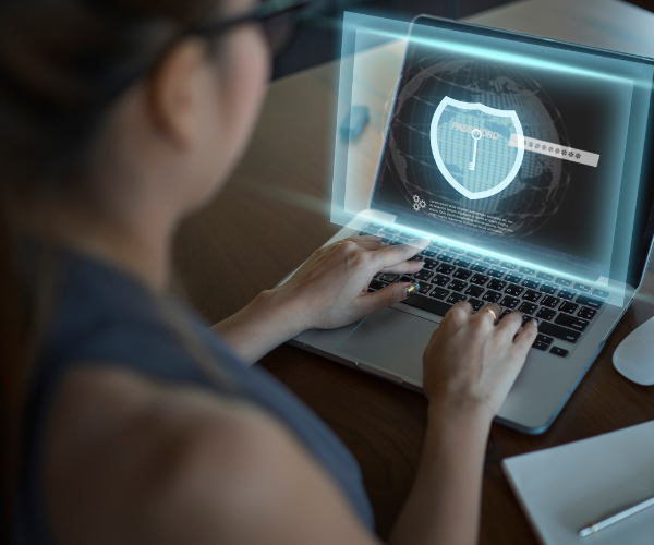 Een dame die achter een laptop een cybersecurity training volgt.
