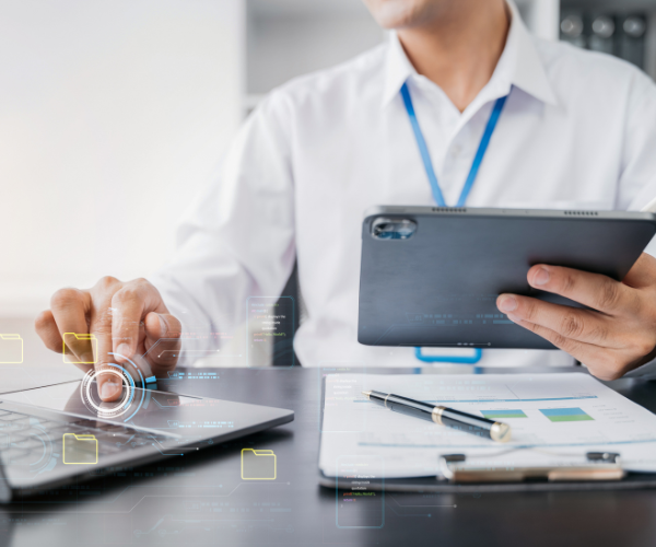Iemand die op een laptop en tablet een IT migratie uitvoert