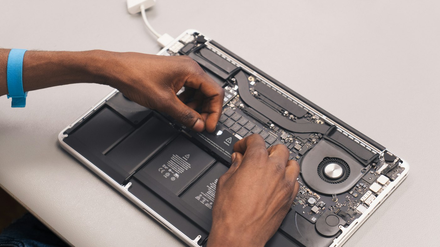 Handen repareren een geopende laptop