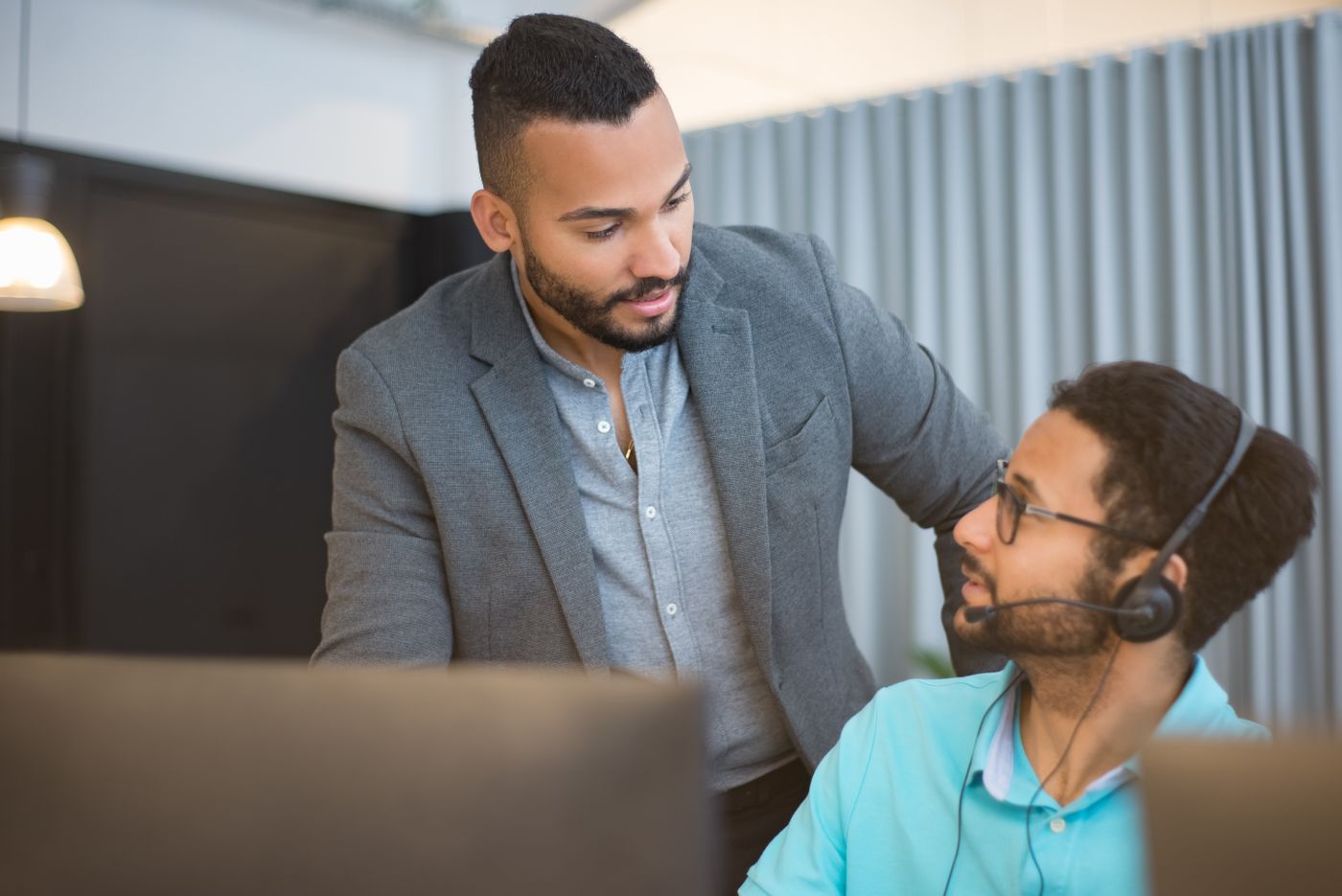 foto-helpdesk-blok Collega helpt een helpdeskmedewerker met headset