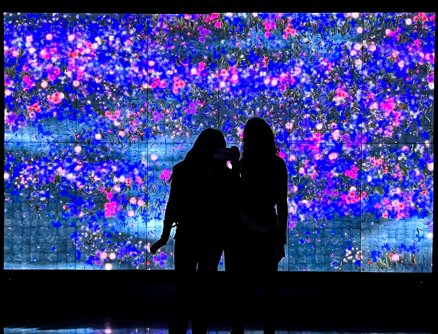 Twee bezoekers voor een grote ledwall