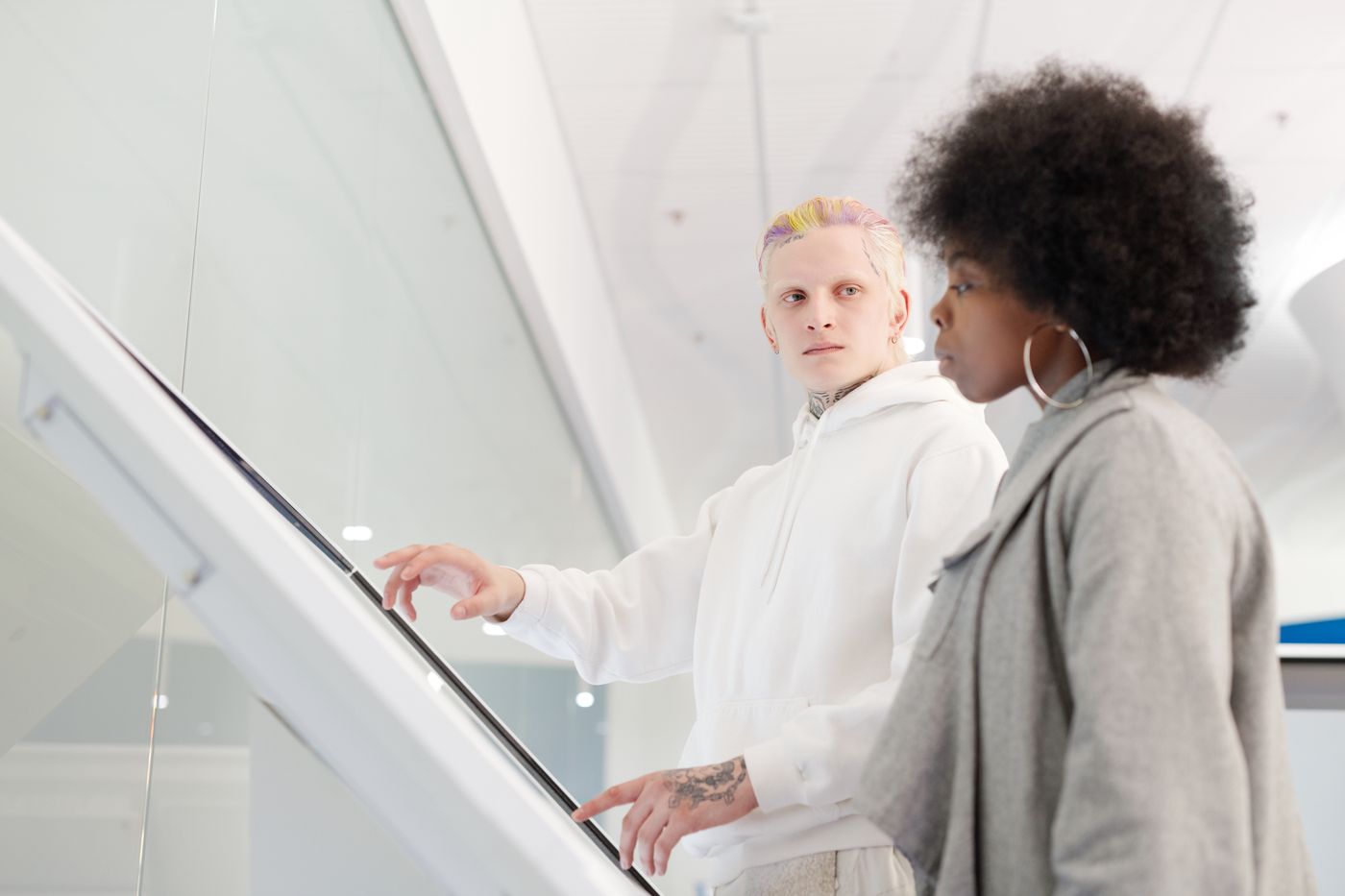 Iemand legt een collega uit hoe een groot touchscreen werkt